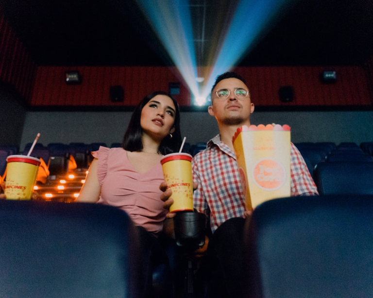 2 women sitting on blue leather chair holding white and red plastic cups — Foto por Felipe Bustillo na Unsplash