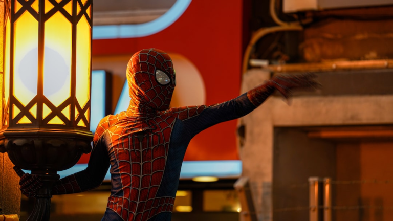 a man in a spider suit holding a lamp — Foto por cal gao na Unsplash